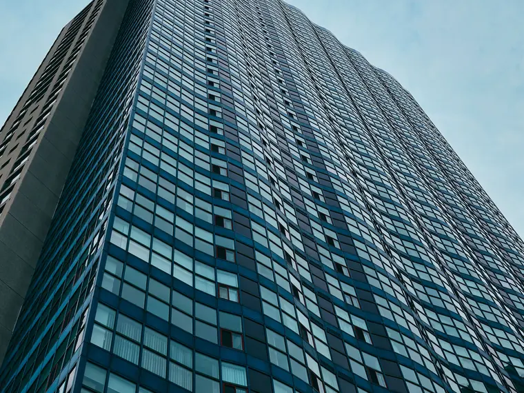 Fachada espelhada de um edifício comercial vista de baixo para cima